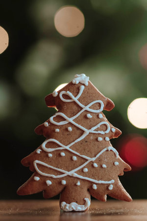 Gingerbread christmas tree against the background of bokeh of garlands of side flickering light...