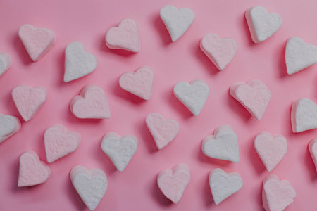 Pink marshmallow hearts on a pink background. The concept of Valentine's Day. February 14.