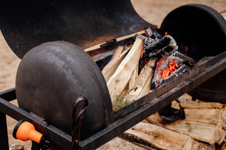 fire burns in a metal brazier against the backdrop of forest and nature.の写真素材