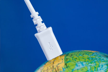 The white USB cable is connected to the globe. Concept