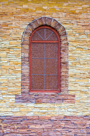 Arched window in vintage style on the facade of a stonework buildingの写真素材