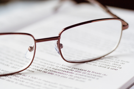 Close up view of a glasses on the open book (concept, background)の写真素材