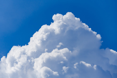 White cumulus fluffy clouds against a bright blue sky (background)の写真素材