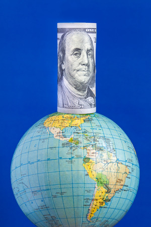 A hundred-dollar bill on top of the globe. Conceptの写真素材