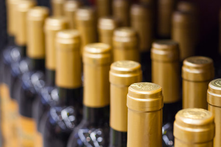 Row of a bottles of wine with golden foil on a neck in the store. Shallow depth of field, selective...