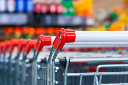 Close up view of a row of push carts in a supermarket on the background of counters in blurの写真素材