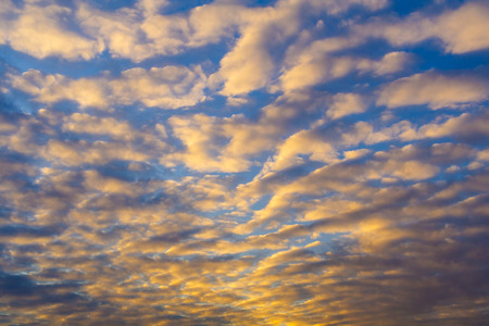 Golden clouds in the sunset sky (background)の写真素材