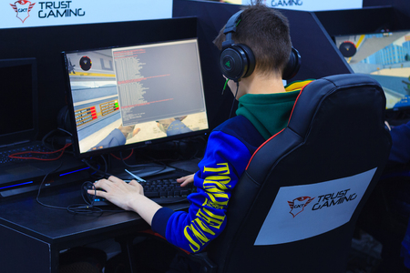 Moscow, Russia, April, 2018: Back view of young gamer on the armchair in headphone playing video game on a e-sport tournament (editorial)のeditorial素材