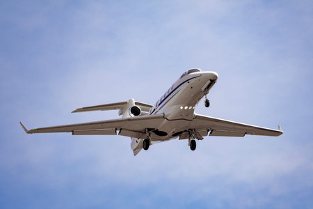 Light business jet flying in cloudy sky