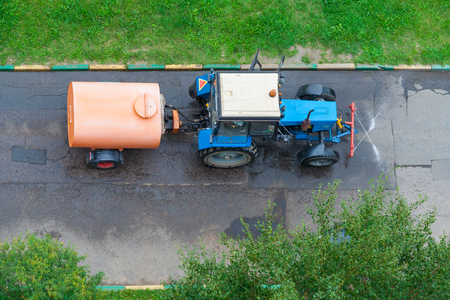 Top view on a tractor with tank for washing the asphalt road in the parkの写真素材