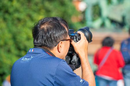 Moscow, Russia, August 2018: Tourist from Asia takes pictures on a DSLR camera against a Monument to Minin and Pozharsky on the Red Square (editorial)のeditorial素材