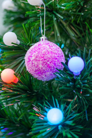 Close up view on a Christmas tree decorated by multicolored ballsの写真素材