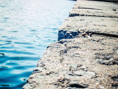 Phoro of stone slabs near the water in focusの写真素材