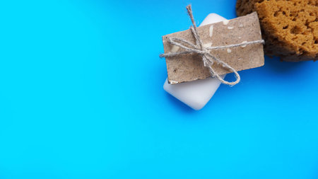 Gray and white Handmade soap wrapped with twine on a blue clean background