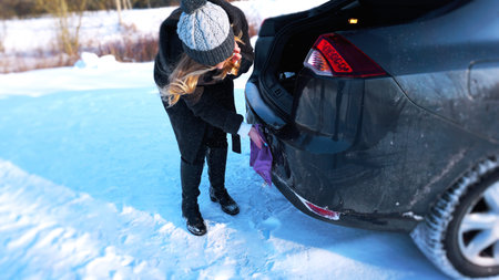 Young woman, driver, dry wiping her car with microfiber rag after washing it, cleaning auto.の写真素材