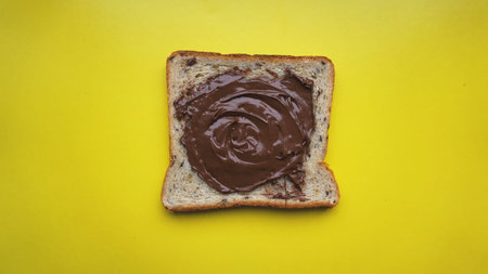 Toast on yellow background - sandwich with chocolate spread. Background for breakfast. View from...