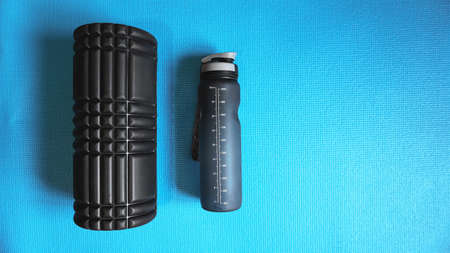 Foam Roller with water bottle Gym Fitness Equipment Blue background self Myofascial Release - MFR.の写真素材