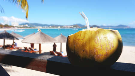 Coconut water drink on a tropical beach. Sea Beach in the backgroundの写真素材