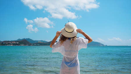 Young woman in white clothing refreshing at the ocean beach, Chinaの写真素材