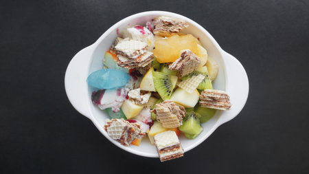 Close up desert with fresh fruit and ice cream. Mixed Fruit With with waffle and fruit ice on black...