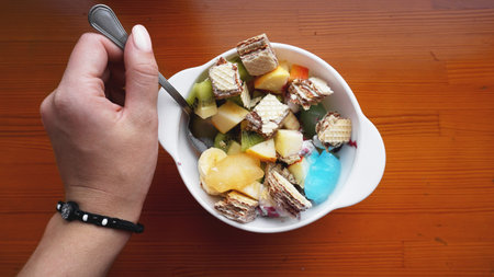 Close up desert with hand. fresh fruit and ice cream. Mixed Fruit With with waffle and fruit ice on...