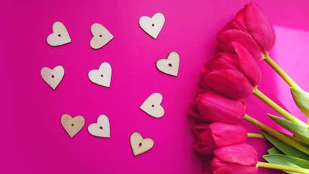 Pink tulips with hearts on the pink background. Flat lay, top view. Valentines background. Spring concept.の写真素材