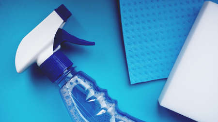 Housework, housekeeping and household concept - cleaning rag, detergent spray on blue backgroundの写真素材