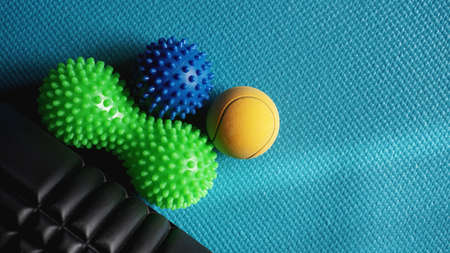 Massage ball and roller for self massage, reflexology and myofascial release, blue background. Equipment for sports, yoga, fitnessの写真素材