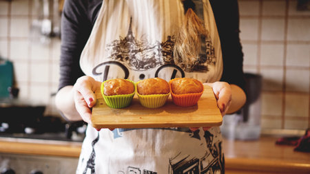Homemade caramel muffins in a baking dish in the hands of the confectioner. Dessert for gourmet....