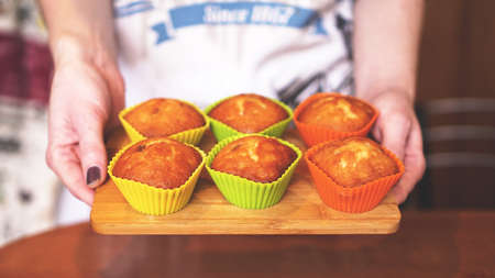 Homemade caramel muffins in a baking dish in the hands of the confectioner. Dessert for gourmet. Selective focusの写真素材
