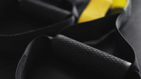 Black and yellow strap functional training equipment on grey background. Sport accessories. Fitness and Gym workout items for Healthy. Banner TRXの写真素材
