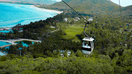 Cable car with tourists inside and against the background of the Hainan Province, Chinaの写真素材