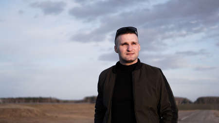 Outdoor portrait of young handsome smiling man - nature backgroundの写真素材