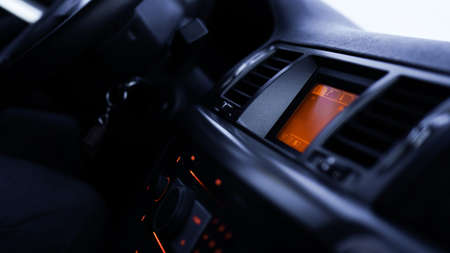 Buttons of radio, dashboard, climate control in car close up - black and orangeの写真素材