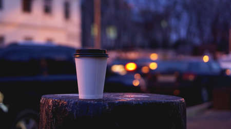 Take away coffee cup empty blank copy space for your design text or banner of brand, hot drink on wood table with beautiful city light decorationの写真素材