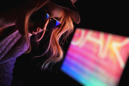 Portrait of the Beautiful Young Pro Gamer Girl. Attractive Girl with Glasses by Neon Lights.の写真素材