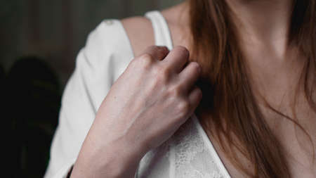 Hands of woman undressing white bra. Hands of woman undressing brassiere. Close-up nude photoの写真素材