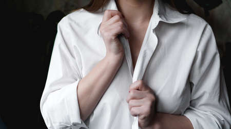 A woman holds her hands for a mens white shirt. Photo without faceの写真素材