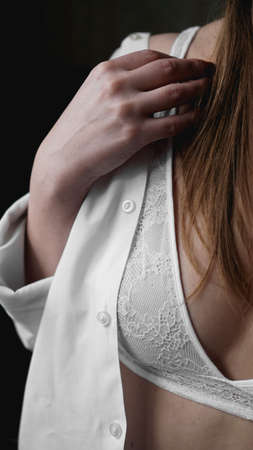 Hands of woman undressing white bra. Hands of woman undressing brassiere. Close-up nude photoの写真素材