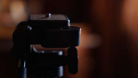 Tripod for camera. Three-legged tripod. Screwing for the camera. Camera control pen. Blurred backgroundの写真素材