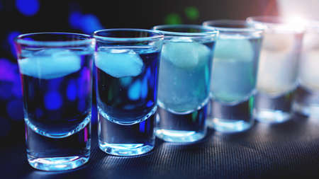 Glasses of vodka with ice. In bar - neon backgroundの写真素材