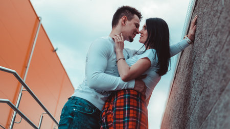 Young loving couples standing next to the brick wall, happy and satisfied, lifestyle concept