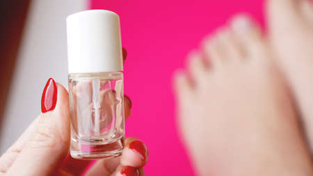 Young perfect groomed womans feet on pink background. Care about nails and clean, soft, smooth body skin. Pedicure and manicure beauty salonの写真素材