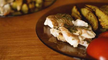 Fish dish - fried fish fillet with fried potatoes and vegetables with spices and rosemary, top view,...