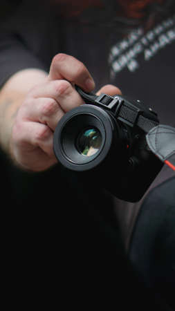 Young man photographer holds camera. Photographer concept.の写真素材