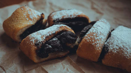 Freshly Baked Chocolate Rolls with a delicious filling, sprinkled with powdered sugar. Against the background of brown craft paperの写真素材