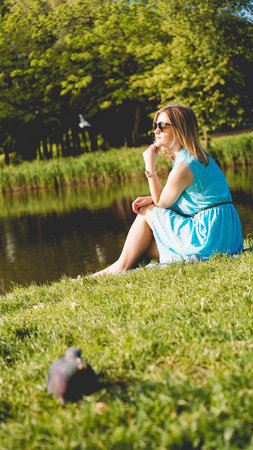 Young woman in sunny garden. Outdoor summer day. Meditation and freedom concept