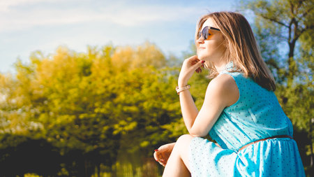 Young woman in sunny garden. Outdoor summer day. Meditation and freedom concept
