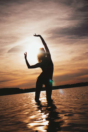 Happy Carefree Woman Enjoying Beautiful Sunset on the Beach - Summer photoの写真素材