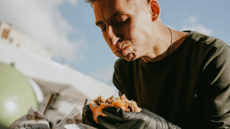 Man enjoing outdoor street food festival, Beer and Burger event. Burger Battle